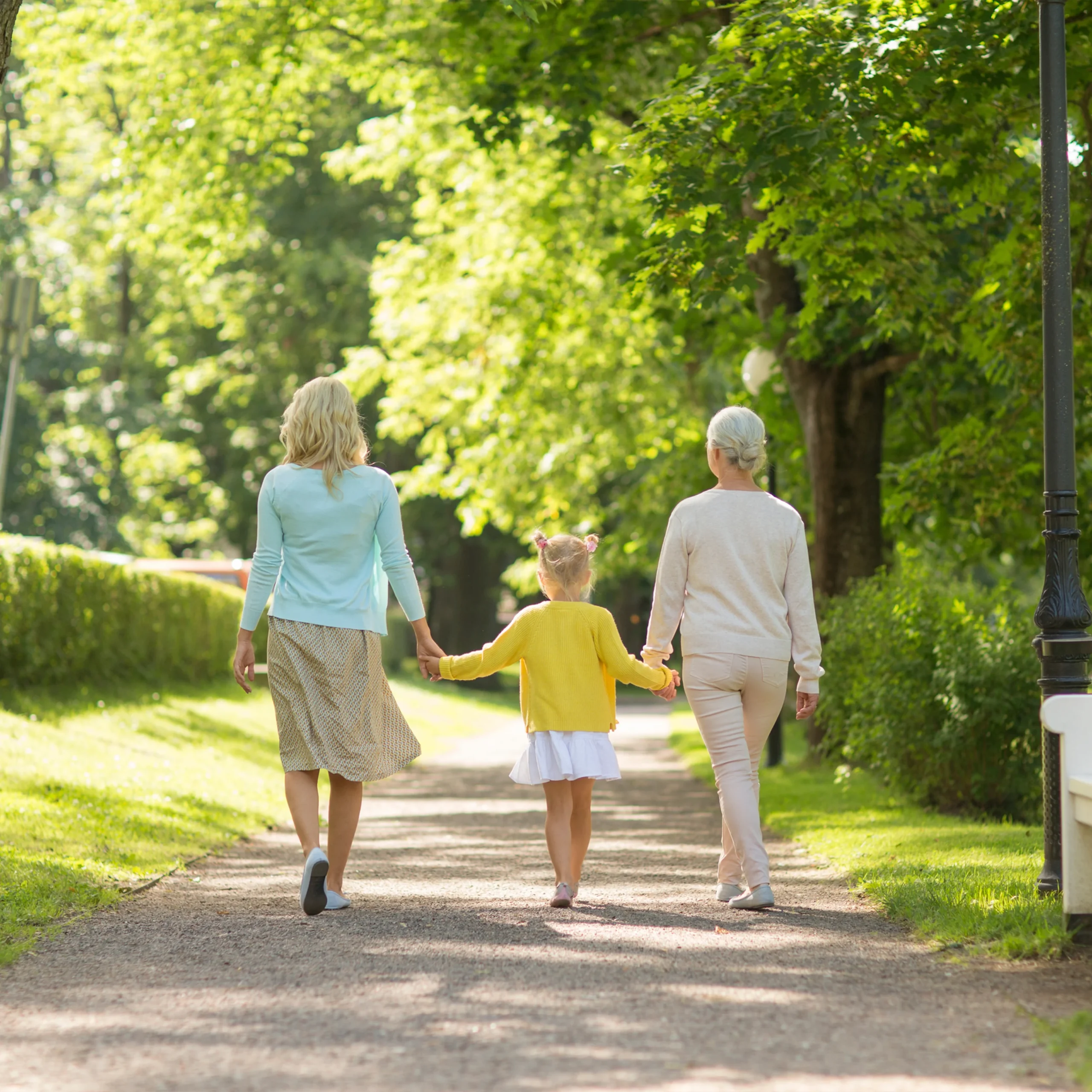 Three generations of women walking down a trail.