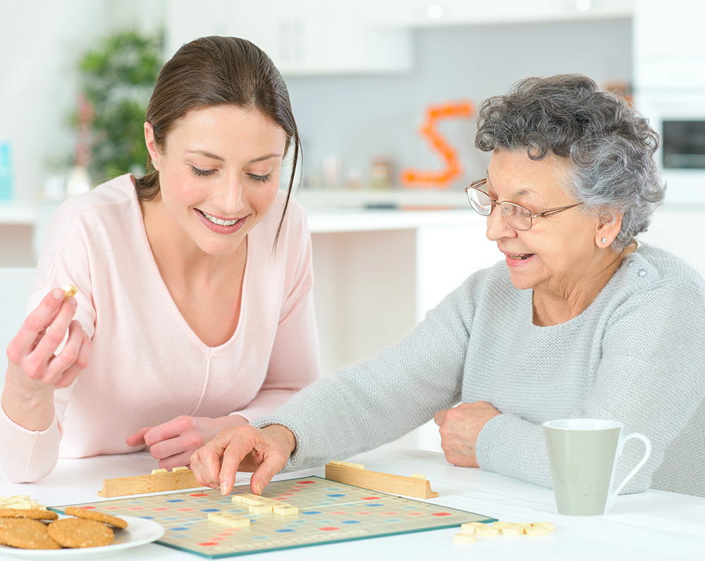 A younger lady playing board games with an older women