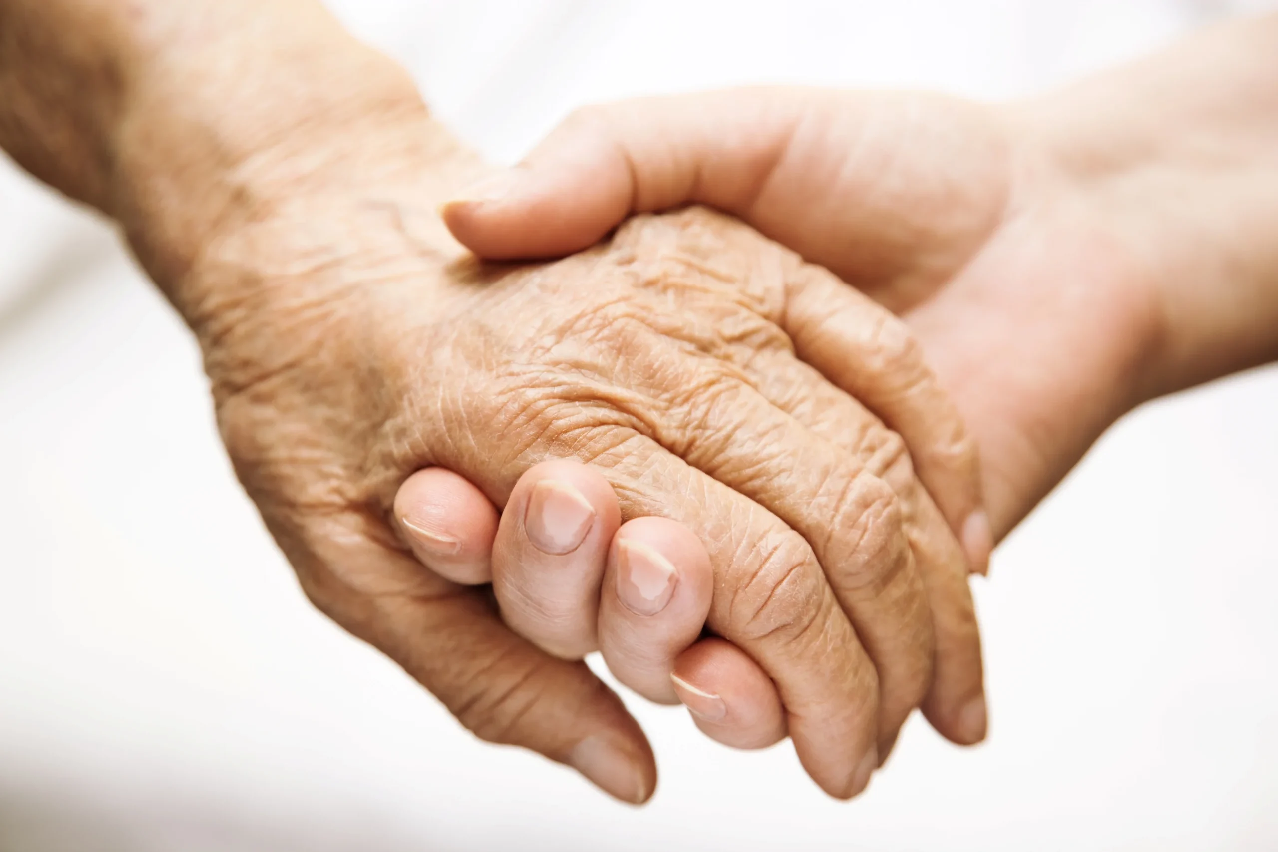 A younger hand holding an older hand.